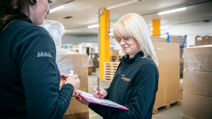 Retourenmanagement bei megapac handling Mitarbeiter prüfen eine Rücksendung im Lager