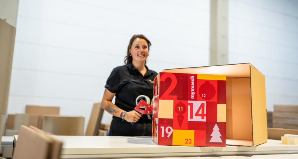 Adventskalender verpacken Im Rahmen der Konfektionierung bei megapac handling verpackt eine Mitarbeiterin einen Adventskalender.