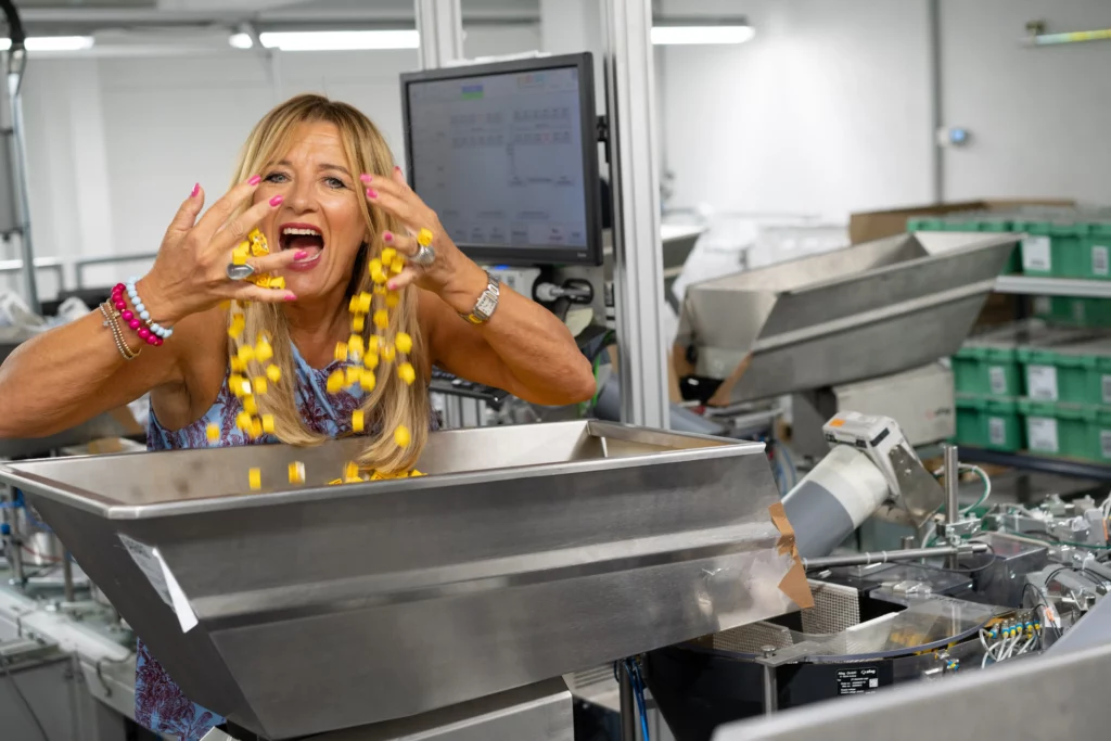 Mitarbeiterin bei der Kontrolle von Waren an einer Verpackungsstation bei megapac.