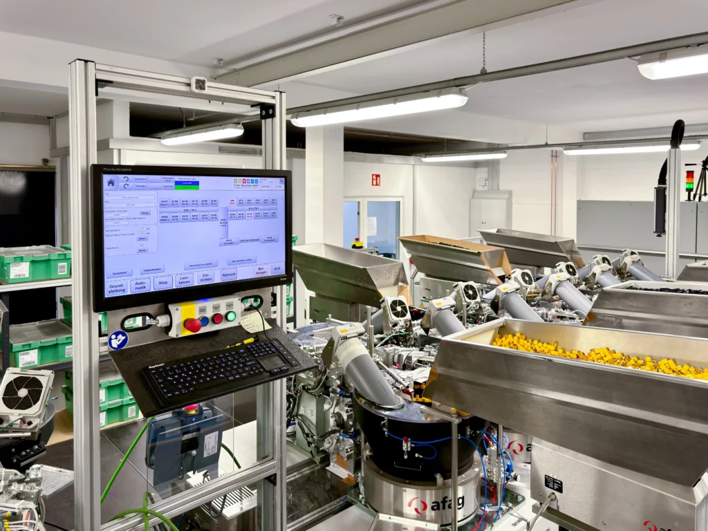 Ein Steuerungsterminal zeigt den Kommissionierungsfortschritt in einem automatisierten Lager.