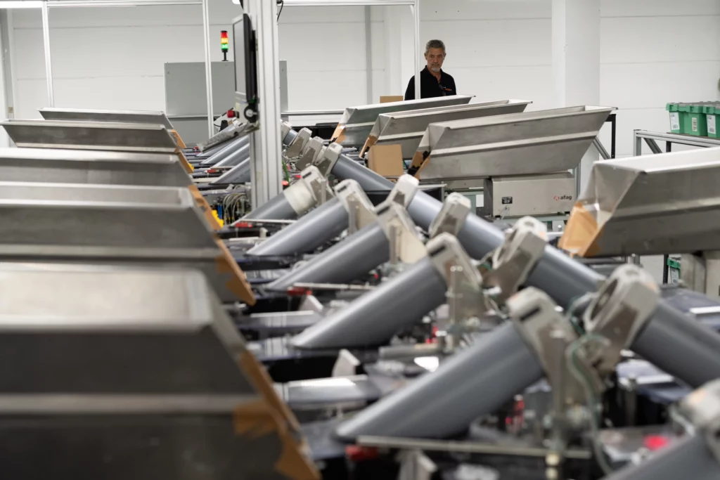 Automated order picking system with conveyor technology and sorting stations in a modern warehouse logistics facility